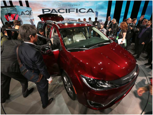 Fiat Chrysler showcased its Pacifica mini van at the North American International Auto Show, seen here being admired from the outside and the interior.