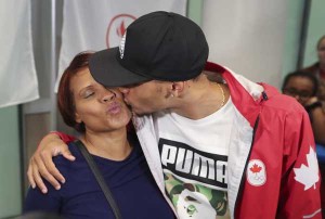 TORONTO, ON - AUGUST, 24 Triple medallist, sprinter Andre De Grasse gives his mom, Beverley a kiss. Plane loads of Canadian Olympians returned to Toronto's Pearson International early Wednesday morning from Rio. August 24, 2016