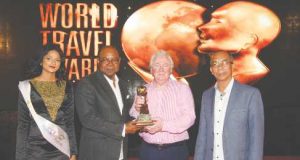 Tourism Minister Edmund Bartlett (2nd left) receives the award of World’s Leading Personality for Outstanding Services to Travel from World Travel Awards President and Founder, Graham Cooke (2nd right). Minister without portfolio in theJamaica's Ministry of Economic Growth and Job Creation, Dr Horace Chang (right)